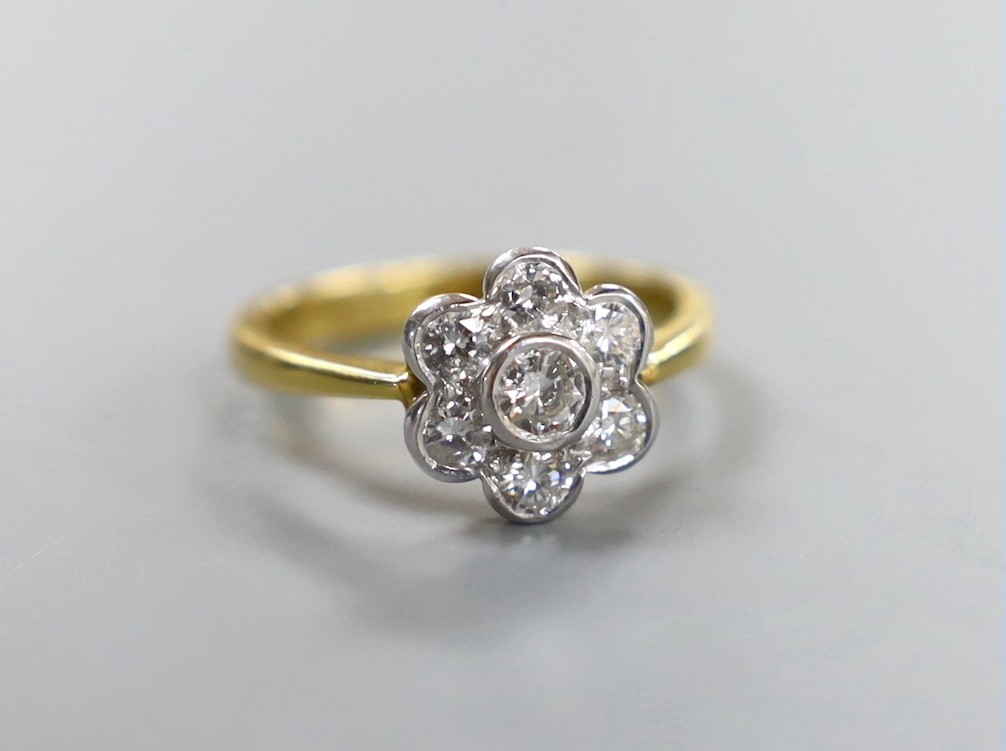 A modern 18ct gold and seven stone collet set diamond flower head cluster ring, size O, gross weight 4.4 grams
